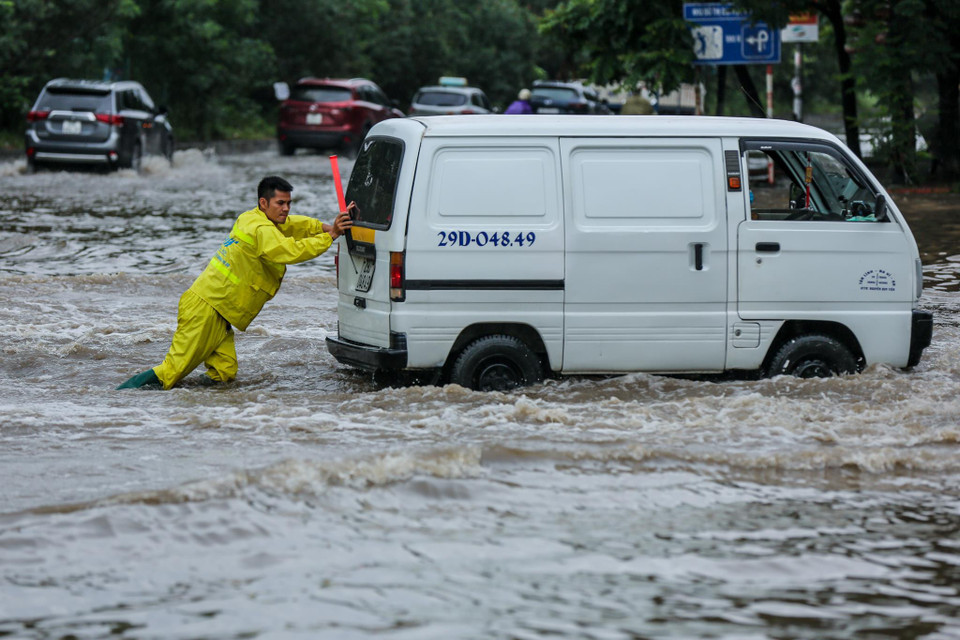 Chiếc xe ôtô chết máy sau khi cố gắng băng qua đoạn đường ngập. (Ảnh: Minh Sơn/Vietnam+)