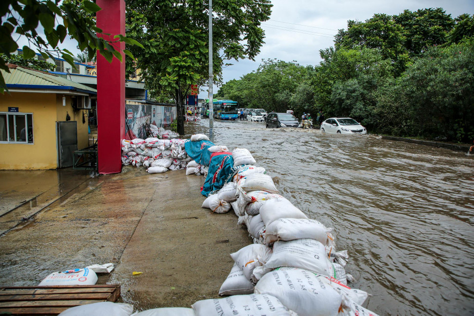 Một nhà xưởng tại khu vực An Khánh đã quen với việc dựng bao cát chắn nước tràn vào sau mỗi trận mưa lớn. (Ảnh: Minh Sơn/Vietnam+0