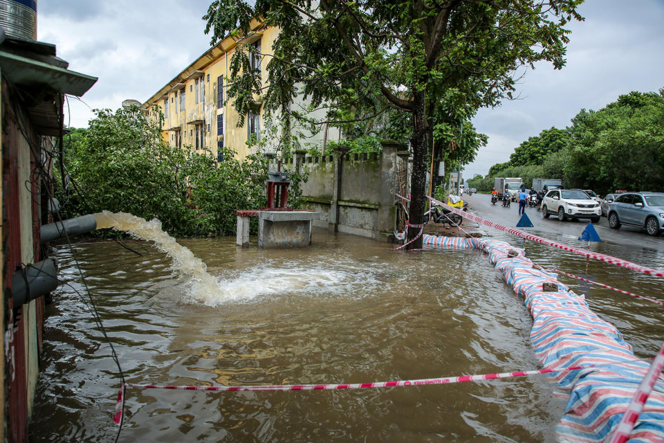 Một số nhà xưởng xảy ra tình trạng ngập sâu, lực lượng cứu hộ đã dựng lớp chắn nước bằng bao tải cát đồng thời chạy máy bơm công suất lớn để tránh nước tràn vào. (Ảnh: Minh Sơn/Vietnam+)