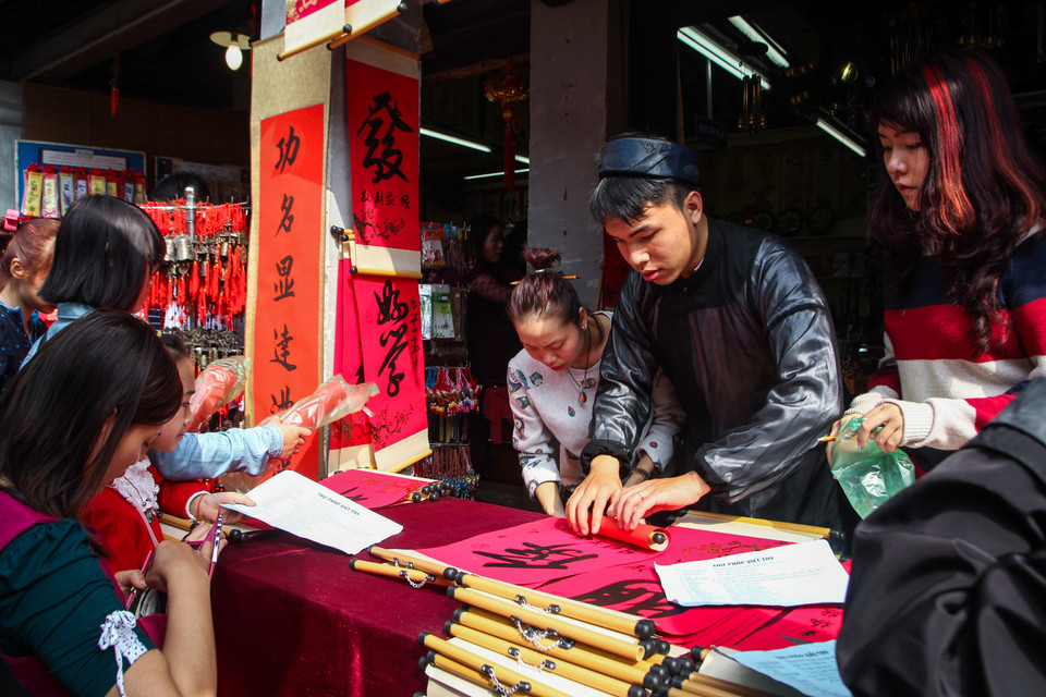 Một số người dân không chịu được cảnh chen lấn đành phải đi mua chữ tại các quầy hàng. (Ảnh: Minh Sơn/Vietnam+)