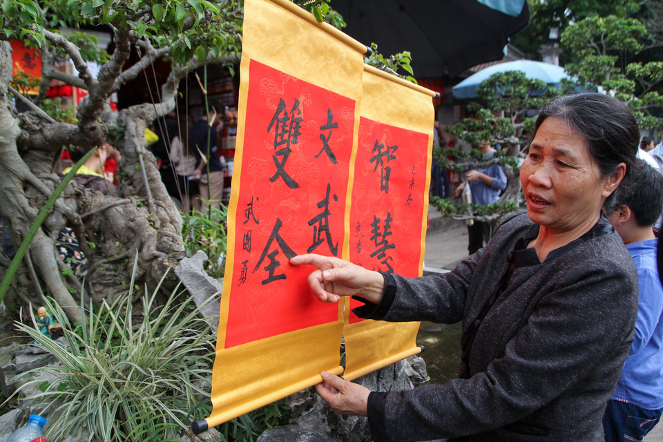 Cô Tân ở Thanh Trì (Hà Nội) chia sẻ, cô lên tận Văn Miếu để xin chữ cho con và cháu của mình. (Ảnh: Minh Sơn/Vietnam+)