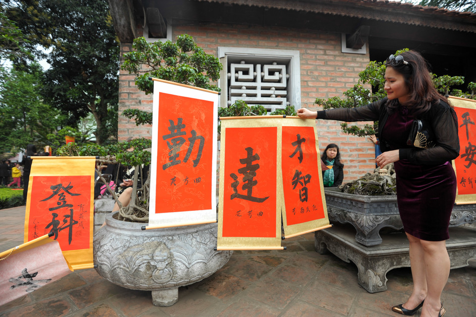Một người dân tại Văn Miếu cho biết, năm nào chị cũng đưa cả gia đình đến đây xin chữ. Mỗi thành viên sẽ được tặng một chữ ứng với mong ước trong năm mới. (Ảnh: Minh Sơn/Vietnam+)