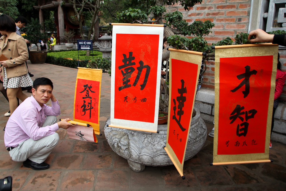 Vất vả xếp hàng hàng tiếng đồng hồ rồi lại phải phơi chữ cho khô. (Ảnh: Minh Sơn/Vietnam+)