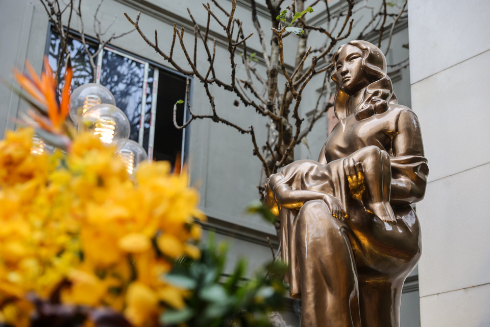 Trung tâm của đài tưởng niệm Khâm Thiên là bức tượng bằng đồng phỏng theo bức tượng bằng ximăng được họa sỹ Nguyễn Tự khắc họa chân dung, dáng vóc của một người phụ nữ Hà Nội. Tay chị ôm đứa con đã chết, bước chân nhấc lên cao đạp lên bom Mỹ. (Ảnh: Minh Sơn/Vietnam+)