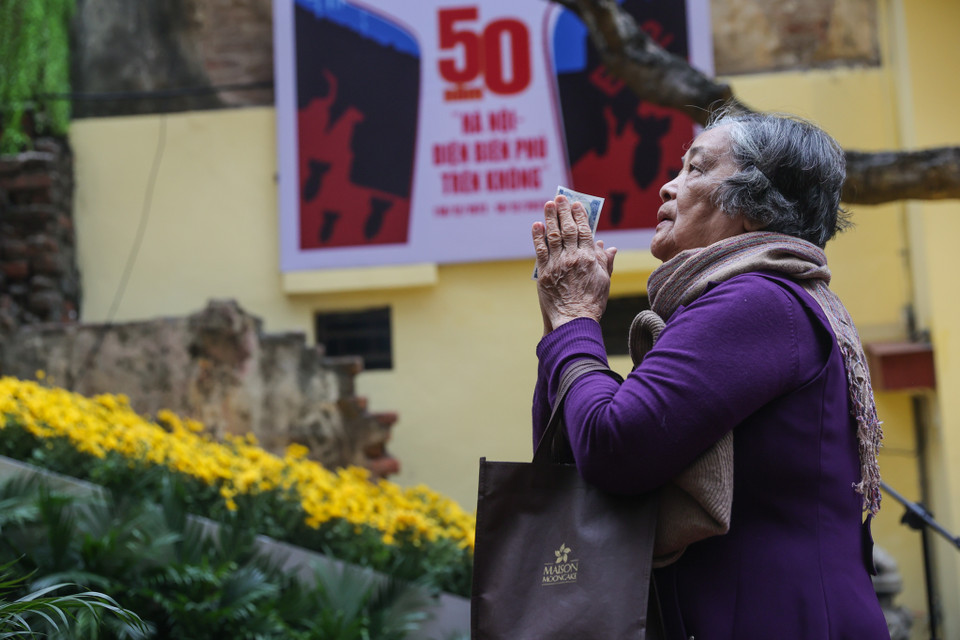 Bà Võ Thị Hợp (85 tuổi) năm nào vào dịp này cũng đến thắp hương ở đài tưởng niệm Khâm Thiên. Trong ký ức kinh hoàng của bà vẫn còn vẹn nguyên hình ảnh khu phố Khâm Thiên hoang tàn, chết chóc. (Ảnh: Minh Sơn/Vietnam+)