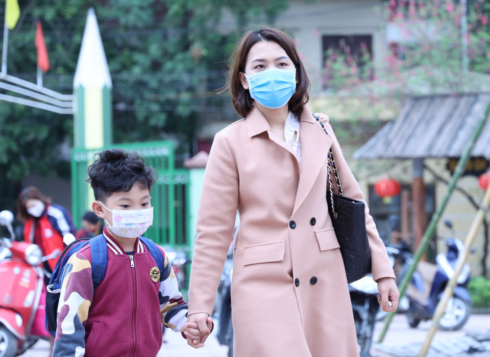 Khoảng 7 giờ, đông đảo phụ huynh đã cho con em tới trường để rồi sau đó đi làm. Nhiều người bày tỏ vui mừng vì con cái được trở lại trường để họ không còn phải vất vả nghỉ làm hay nhờ ông bà nội, ngoại trông nom. (Ảnh: Tá Hiển/Vietnam+)