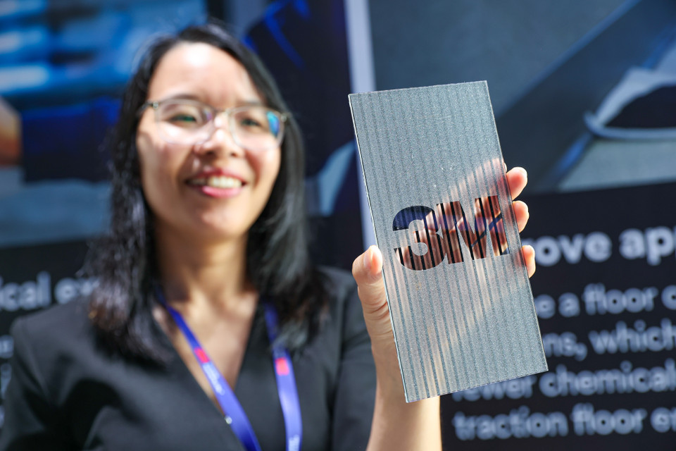 Hướng dẫn viên giới thiệu những vật liệu phim dán giả kim loại, gỗ,... để trang trí nội thất của 3M. (Ảnh: Minh Sơn/Vietnam+)