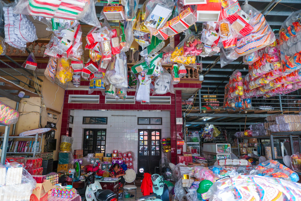 Bước vào làng Song Hồ những ngày này, dễ dàng nhận thấy nhất sự vắng lặng khác thường. Những gian hàng vàng mã, từ những mô hình nhà cửa, xe cộ đến quần áo, tiền giấy, đều chất đầy nhưng lại thiếu vắng khách hàng. Không còn hình ảnh người dân tấp nập lựa chọn, mặc cả như trước. (Ảnh: Minh Sơn/Vietnam+)