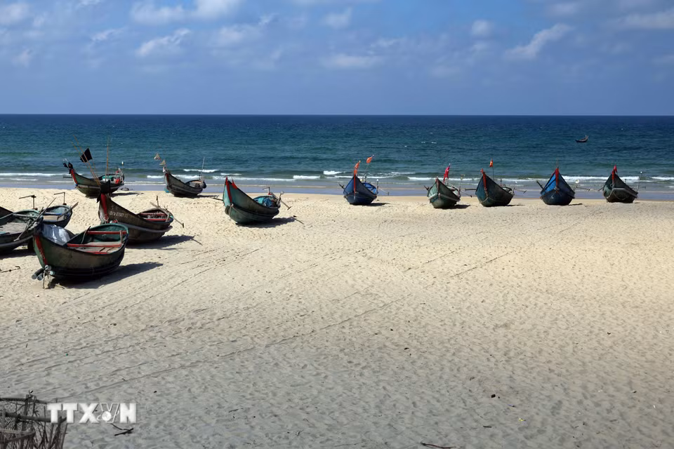 Những chiếc thuyền khai thác hải sản nhỏ của ngư dân nằm "phơi mình" trên bãi cát trắng mịn tạo thành một bức tranh tuyệt đẹp. (Ảnh: Đỗ Trưởng/TTXVN)