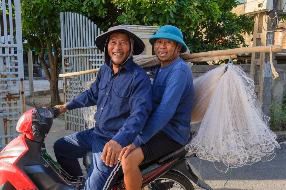 Ngư dân phường Hải Ninh cùng nhau mang ngư cụ ra biển để kéo lưới rùng. (Ảnh: Hữu Quyết/TTXVN)