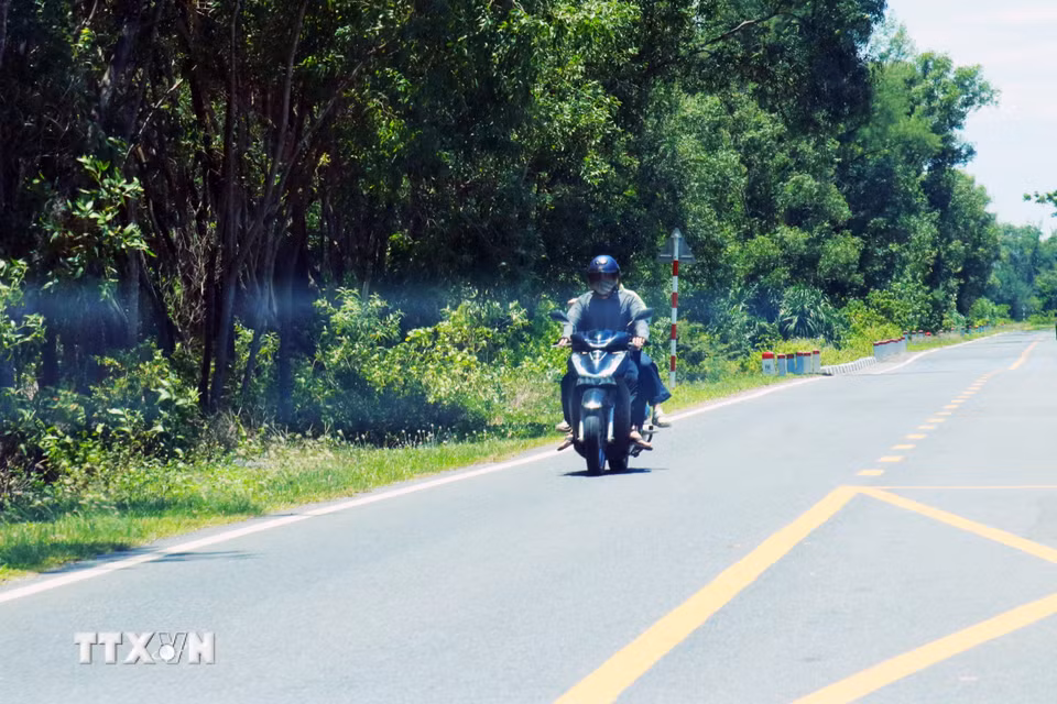 Người dân mặc đồ bảo hộ tránh nắng khi ra đường. (Ảnh: Tường Vi/TTXVN)