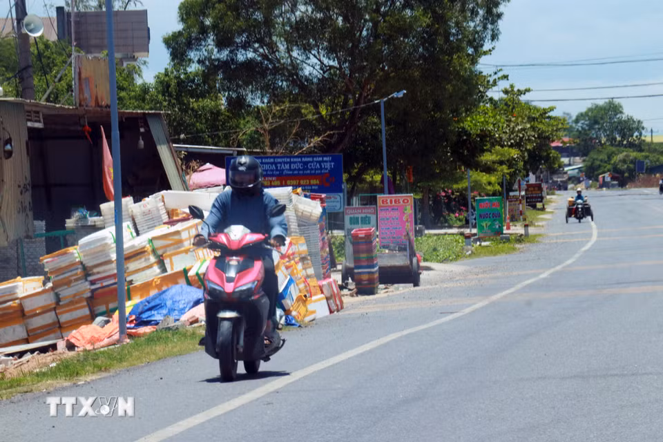 Người dân mặc đồ bảo hộ tránh nắng khi ra đường. (Ảnh: Tường Vi/TTXVN)