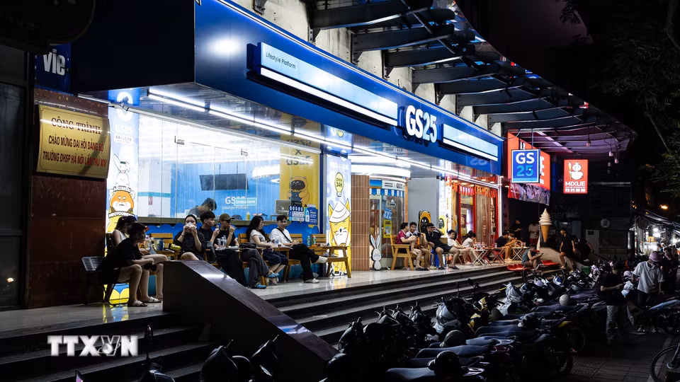 Các cửa hàng tiện lợi mở cửa 24/7 luôn đỏ đèn, thu hút đông đảo giới trẻ và sinh viên tập trung trò chuyện, ăn uống về đêm. Sự bùng nổ của các chuỗi bán lẻ 24/7 không chỉ đáp ứng nhu cầu sinh hoạt xuyên đêm của người dân đô thị hiện đại mà còn là mảnh ghép hạ tầng dịch vụ quan trọng, thúc đẩy hệ sinh thái kinh tế đêm phát triển đa dạng và năng động tại Hà Nội. (Ảnh: Tiến Long/TTXVN phát)