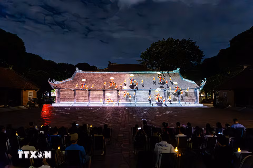 Màn trình chiếu công nghệ 3D Mapping hiện đại trên kiến trúc cổ kính của Văn Miếu tái hiện hành trình đạo học Việt Nam trước đông đảo khán giả. Công nghệ chiếu sáng nghệ thuật thực cảnh đã biến các di tích lịch sử thành những "sân khấu đêm" sống động, tạo nên sản phẩm du lịch đêm đặc sắc giữ chân du khách. (Ảnh: Tiến Long/TTXVN phát)