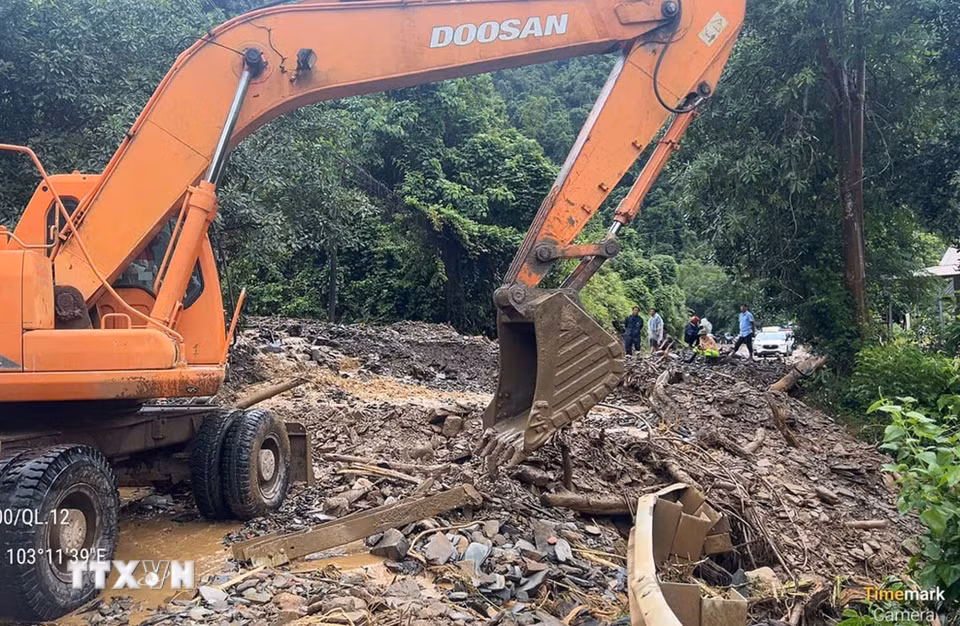 Các đơn vị tập trung phương tiện máy móc khắc phục hậu quả của mưa lũ gây ra tại km 81+100 trên Quốc lộ 12. (Ảnh: TTXVN phát)