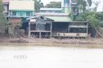 Bờ Bắc sông Bồ, thành phố Huế, sạt lở sát vào nhà ở của người dân. (Ảnh: Nguyên Lý/TTXVN)