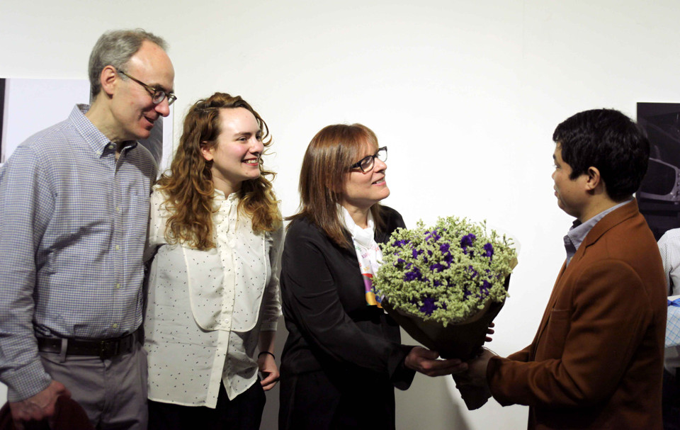 Gia đình nhiếp ảnh gia Debbie nhận hoa cảm ơn từ ông Đoàn Hữu Minh (Trưởng phòng Công tác xã hội, Cục Bảo trợ Xã hội). (Ảnh: Doãn Đức/Vietnam+)