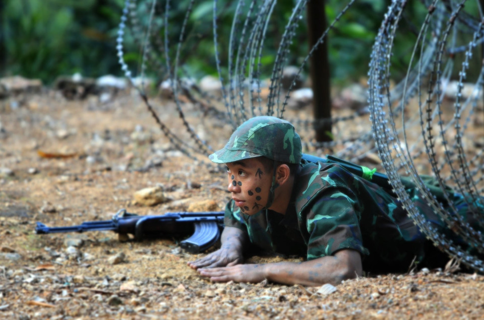 Chiến sỹ Đặc công 113 huấn luyện trườn qua những vòng thép gai sắc nhọn. (Ảnh: An Đăng/TTXVN)