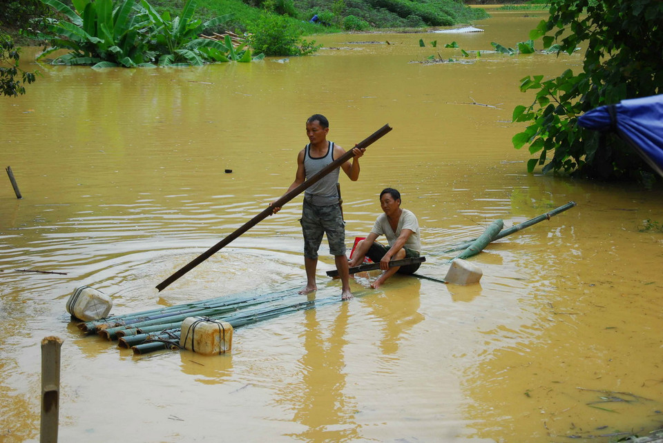 Người dân phải đi lại trong bản bằng bè tre. (Ảnh: Xuân Tư/TTXVN)