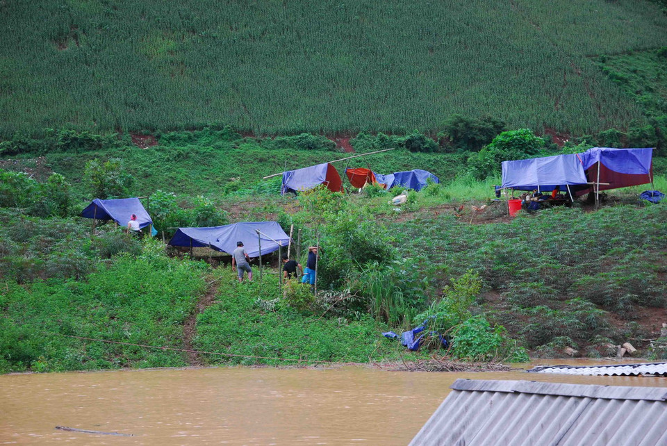 Bà con dựng lán tạm để có chỗ trú trong những ngày tiếp theo. (Ảnh: Xuân Tư/TTXVN)