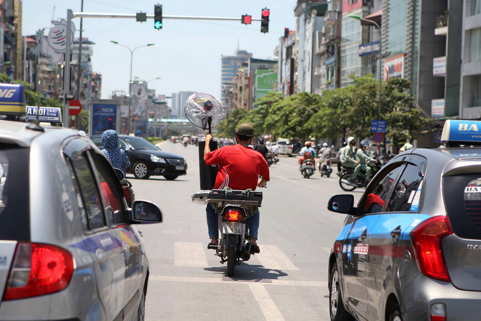  Do trời nóng nhiều người tham gia giao thông đã bất chấp hiệu lệnh của tín hiệu đèn. (Ảnh: Minh Quyết/Vietnam+)