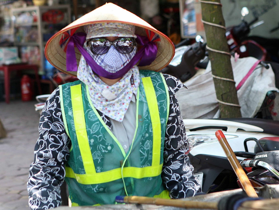 Người lao công trang bị thêm cho mình kính chống nắng. (Ảnh: Minh Quyết/Vietnam+)