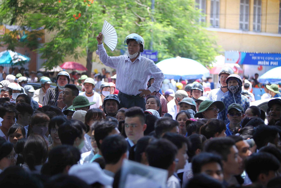 Tâm trạng lo lắng giữa cái nóng khiến sự chờ đợi của các bậc phụ huynh trong lúc con thi khiến thời gian như dài thêm. (Ảnh: Quý Trung/TTXVN)