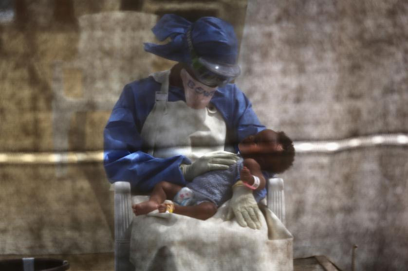 Y tá Benetha Coleman đồng thời là người từng bị nhiễm virus Ebola đang chăm sóc cho bé gái sơ sinh có triệu chứng của Ebola ở Liberia tháng 1/2015. (Nguồn: Getty Images)