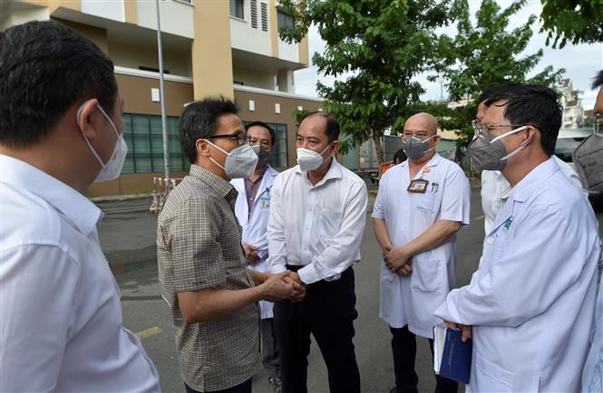 Phó Thủ tướng Vũ Đức Đam kiểm tra Bệnh viện dã chiến Thu Dung điều trị COVID-19 số 2 và trao đổi với lãnh đạo bệnh viện. (Ảnh: TTXVN)