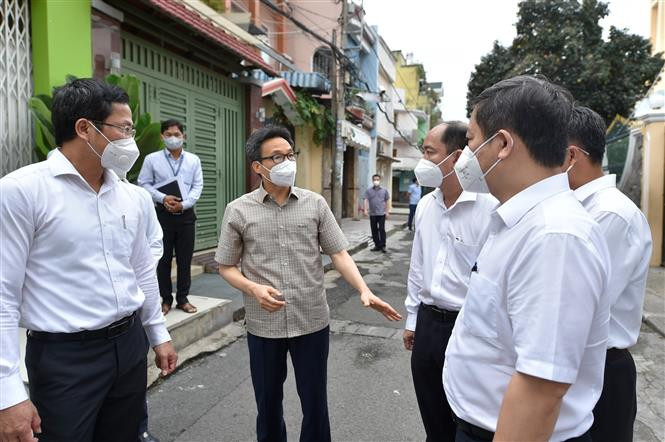 Phó Thủ tướng Vũ Đức Đam nghe lãnh đạo Quận 12 báo cáo phương án bảo đảm cung cấp nhu yếu phẩm cho người dân trong thời gian thực hiện giãn cách xã hội. (Ảnh: TTXVN)