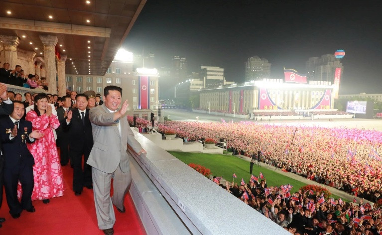 Nhà lãnh đạo Triều Tiên Kim Jong-un vẫy chào các binh sỹ, khán giả và những người tham gia cuộc diễu hành. (Nguồn: aljazeera.com)