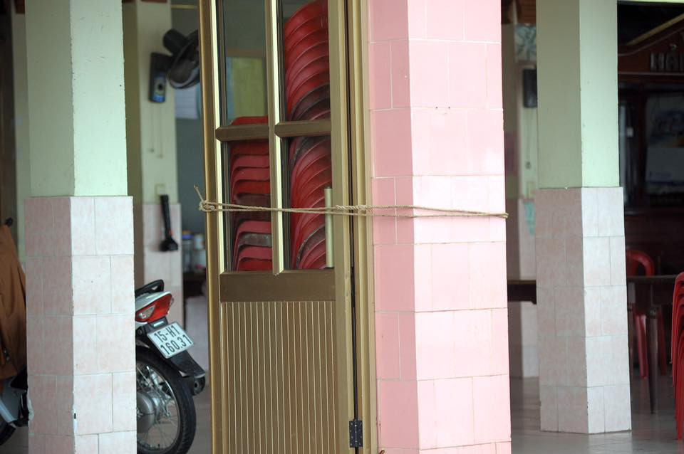 Người dân lấy giây buộc chặt cửa để ngăn bão (Nguồn: Vietnam+)