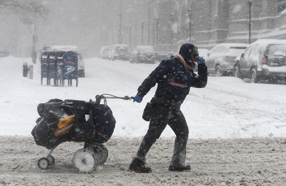Một người đưa thư đi lại trong mưa tuyết ở New York, ngày 4/1. (Nguồn: AFP)
