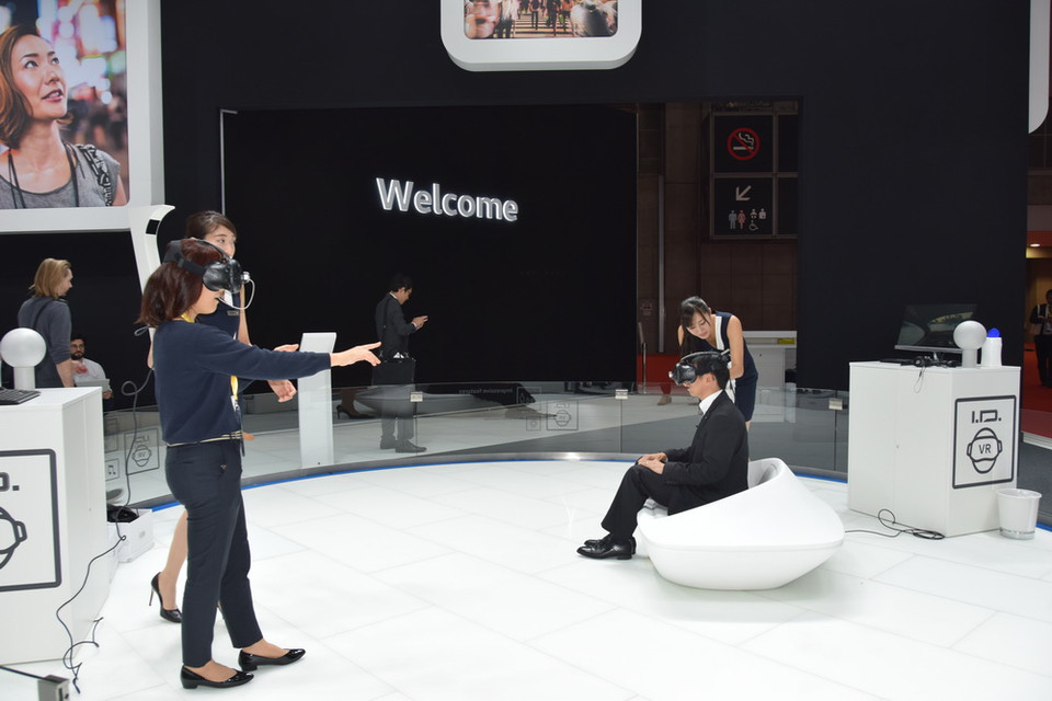 Khách tham quan trải nghiệm xem một mẫu xe của Volkswagen trong thế giới ảo qua kính thực tế ảo (VR). (Ảnh: Cẩm Tuyến/Vietnam+) 