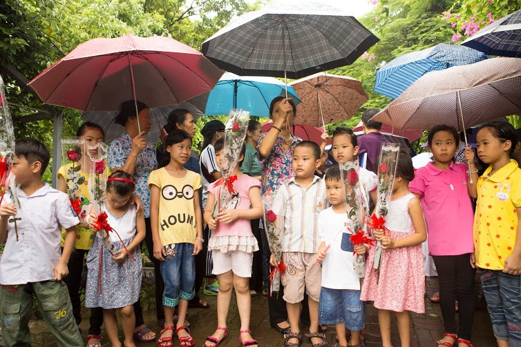 Bất chấp cơn mưa nặng hạt vào đầu giờ chiều, các em nhỏ tại làng trẻ SOS vẫn rất hào hứng chờ đợi ngài đại sứ xuất hiện. (Ảnh: Tiến Đạt/Vietnam+)
