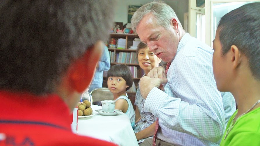 Ngài đại sứ chia sẻ với các em nhỏ về hình ảnh lá cờ nước Mỹ trên chiếc huy hiệu ông đeo trên ngực áo. Ông rất vui khi được giúp các em hiểu hơn về đất nước Mỹ cũng như cải thiện khả năng nói tiếng Anh. (Ảnh: Tiến Đạt/Vietnam+)