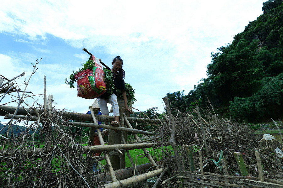  Qua được con suối, người dân còn phải vất vả di chuyển đoạn đường dài mới ra được gần trung tâm xã. (Ảnh: Phan Tuấn Anh/TTXVN)