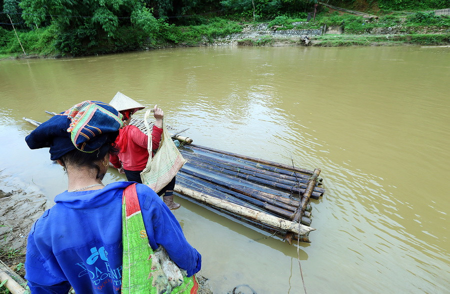 Hơn 3 năm trước, khi cây cầu treo bắc qua suối Nậm Hua không tồn tại nữa thì việc đi lại đi với bà con dân tộc ở bản Pom Sinh rất khó khăn khi phải dùng bè mảng nhỏ, thô sơ qua suối. (Ảnh: Phan Tuấn Anh/TTXVN) 
