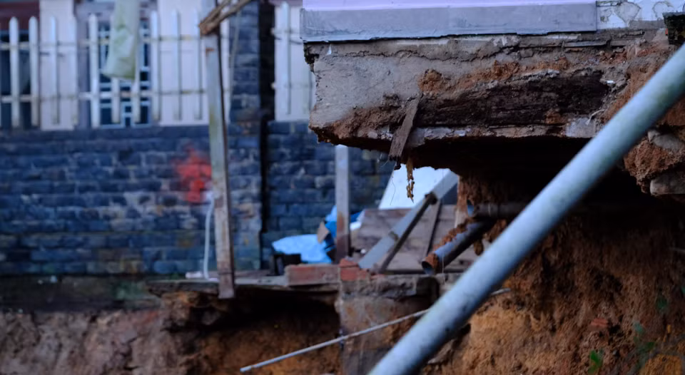 Đoạn sạt lở chạy dài phía sau nhà dân khoảng 50m, tạo thành một lòng chảo, đe dọa đến sự an toàn của nhiều ngôi nhà. (Ảnh: Ngọc Dũng/TTXVN)