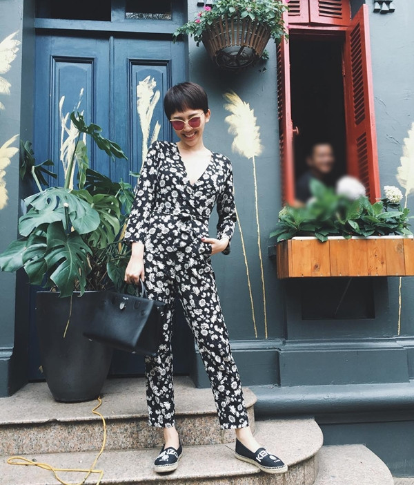 Tóc Tiên nổi bật với bộ jumpsuit (áo liền quần) cổ xẻ sâu, in họa tiết hoa đẹp mắt. Giám khảo 'Thần tượng âm nhạc nhí' tạo sự thú vị cho set đồ với giày lười đế cói của Kenzo, phối cùng túi xách Diorever của Dior.