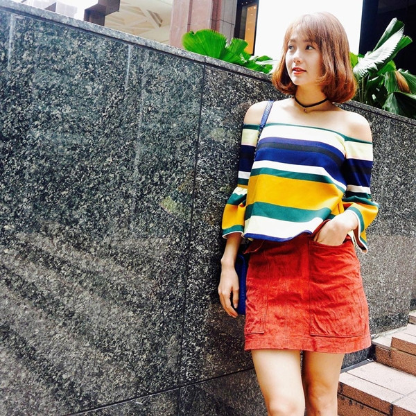 Minh Hằng khuấy động 'sàn diễn đường phố' cùng những gam màu rạng rỡ. Cô chọn áo trễ vai kẻ đa sắc, mix cùng chân váy ngắn và nhấn nhá nét phóng khoáng bằng vòng cổ choker.