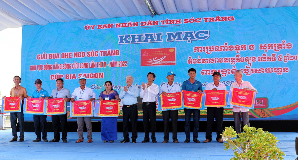 Bí thư Trung ương Đảng, Chủ tịch Ủy ban Trung ương Mặt trận Tổ quốc Việt Nam Đỗ Văn Chiến và Bí thư Tỉnh uỷ Sóc Trăng Lâm Văn Mẫn trao cờ lưu niệm cho các đội đua dự giải tại Lễ khai mạc. (Ảnh: Trung Hiếu/TTXVN)