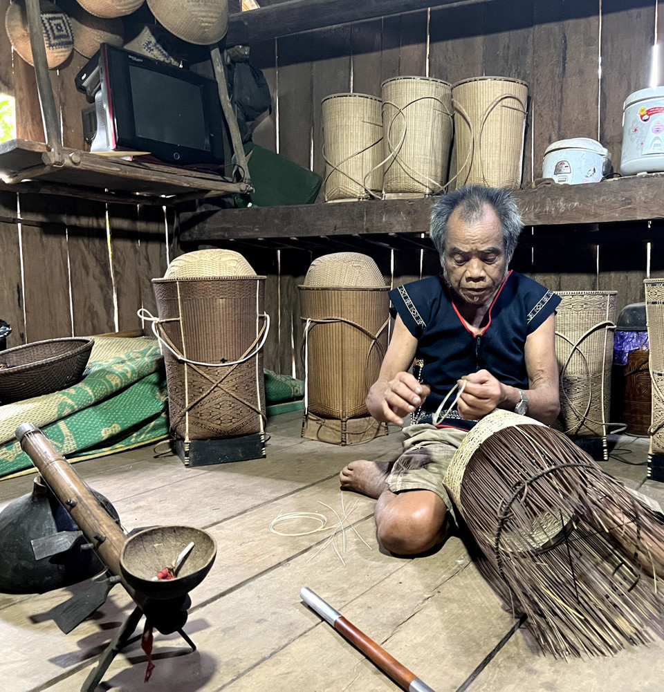 Nghệ nhân Đinh Bi đan những chiếc gùi họa tiết sắc sảo. (Ảnh: Hồng Điệp/TTXVN)