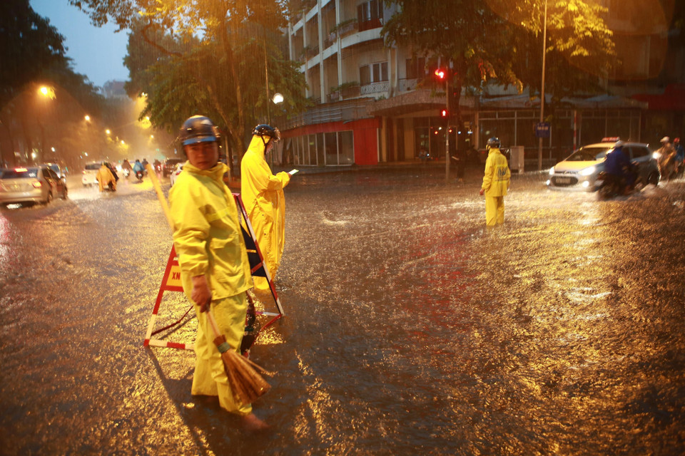 Công nhân Công ty Cấp thoát nước Hà Nội kịp thời có mặt để xử lý những điểm ngập úng. (Ảnh: Trọng Đạt/TTXVN)