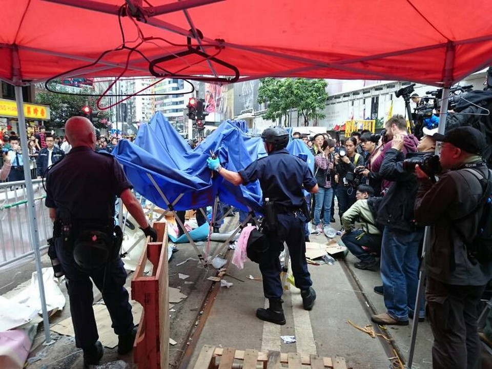 Sau khi dỡ bỏ chướng ngại vật ngăn đường Yee Wo, cảnh sát bắt đầu dỡ bỏ khu lều trại của người biểu tình. (Ảnh: Hà Ngọc/TTXVN)