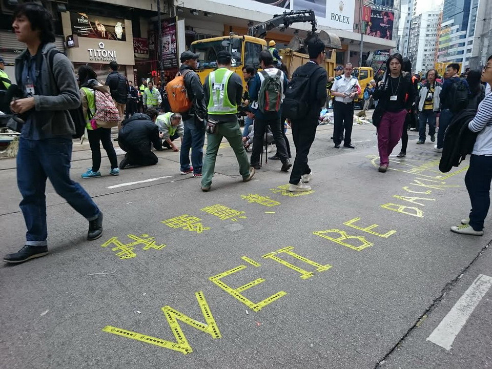 Dòng chữ "chúng tôi sẽ trở lại" được người biểu tình dán trên đường Yee Woo ở Causeway Bay. (Ảnh: Hà Ngọc/TTXVN)