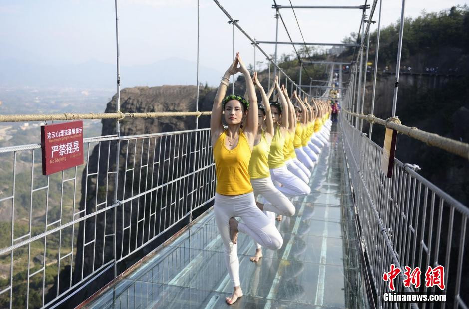 Hơn 100 người thực hiện bài tập yoga trên cầu kính cao 180m ở thị trấn Shi'niu, tỉnh Pingjiang, tỉnh Hồ Nam, Trung Quốc ngày 5/11. (Nguồn: Chinanews.com)