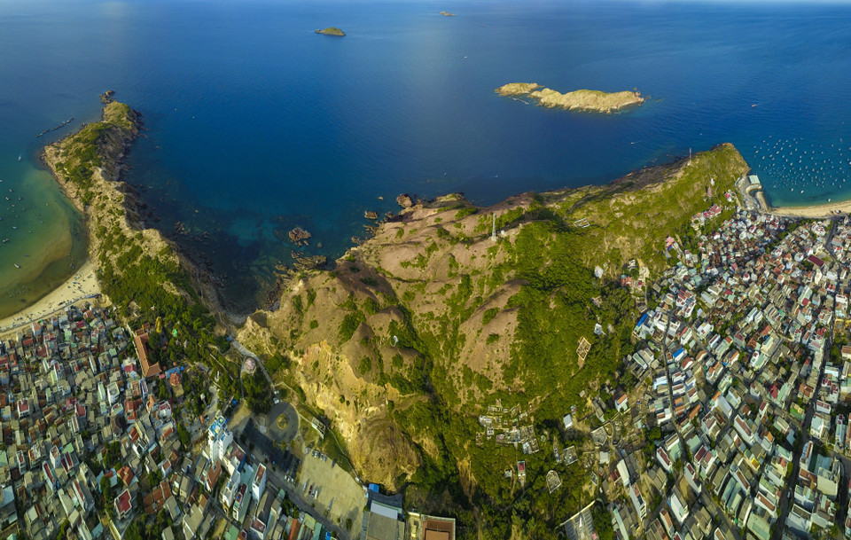 Nhìn từ xa, Eo Gió giống như một cái yên ngựa, nằm giữa hai mỏm núi cao kề bên biển, mặt khác nếu đứng từ trên cao nhìn xuống lại tựa như một cái phễu, vì thế Eo Gió luôn đón gió từ biển thổi vào với sức gió rất mạnh. (Ảnh: Minh Đức/TTXVN)