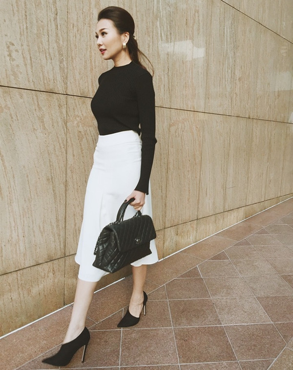 Để tạo điểm nhấn cho bộ cánh hai màu đen trắng tối giản, Thanh Hằng chọn phụ kiện là đôi giày cao gót có thiết kế độc đáo. Kiểu tóc bới cao nữ tính cũng giúp siêu mẫu khoe được nét tươi tắn, rạng ngời.
