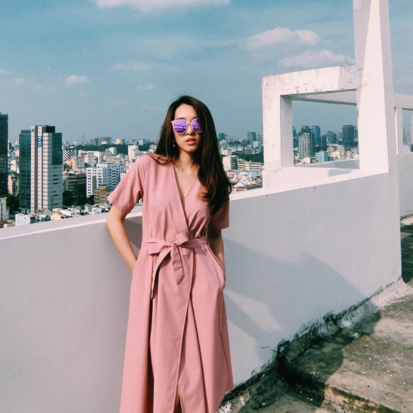 Emily 'phiêu' cùng đầm quấn màu hồng phấn ngọt ngào. Nữ ca sỹ Hà Thành mix với kính mắt tráng gương thời thượng, tạo sự đối lập lôi cuốn.